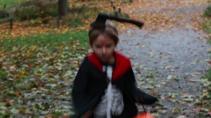 Wall Mural - Boy in a forest with Halloween costumes, carved pumpkins with candles and decoration, creepy concept