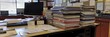 © Somsom - A tidy teacher s desk with neatly arranged papers a computer and a stack of assignments symbolizing the busy schedule and responsibilities of an educator