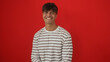 © Krakenimages.com - Handsome young hispanic man smiling against a bright red background, wearing a white striped shirt.