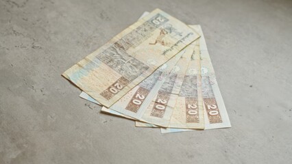 Five egyptian banknotes of twenty pounds laid out on a concrete surface, showcasing the design and currency of egypt.