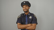 © Krakenimages.com - A confident african american police officer with crossed arms standing against a white background, exuding authority and professionalism.