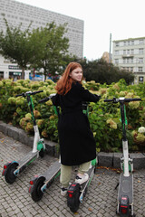 girl rents an electric scooter for move around the city. Choose eco transport and contemporary mobility