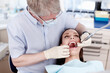 © peopleimages.com - Dentist, tools and woman with tooth extraction, medical check and patient consultation for oral care. Wellness, consulting and hospital for dental hygiene, assessment and healthcare examination