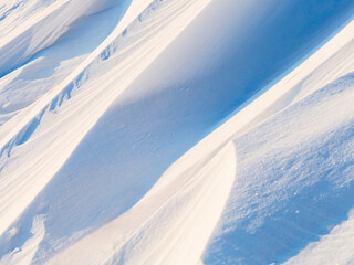 Wall Mural - Snow texture. Wind sculpted patterns on snow surface. Wind in the tundra and in the mountains on the surface of the snow sculpts patterns and ridges (sastrugi). Arctic, Polar region. Winter background