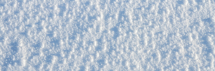 Wall Mural - Natural snow texture. The surface of an icy snow crust. Snowy ground. Winter background with snow patterns. Perfect for Christmas and New Year design. Closeup top view.