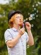© Voyagerix - Man blowing soap bubbles, having fun