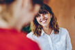 © BullRun - Curly woman with wide smile looking at colleague in multiracial group of people