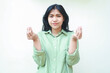 © M Alfan Setyawan - clueless asian woman with dark hair looking at camera with confusion expression raising two palms sideways with curled up finger wearing green oversized shirt, showing and presenting gesture