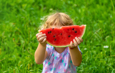 Poster - Child eats watermelon in summer. Selective focus.