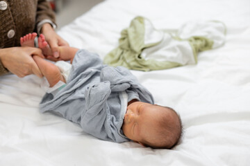 Canvas Print - Mother moving baby legs to remove the gas from tummy