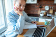 © Davor - Young woman working on laptop at home