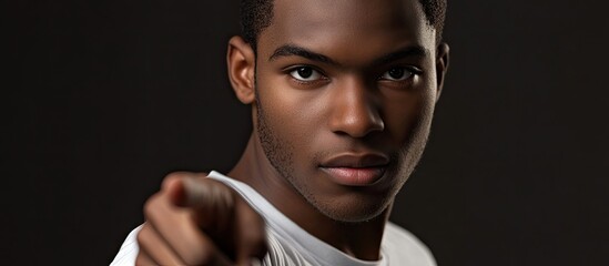 Portrait of a young African American man pointing at the viewer. with copy space image. Place for adding text or design