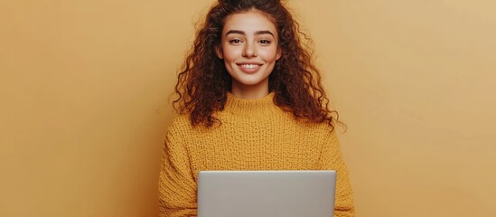 Aufkleber - Cheerful young woman stands alone against a beige background while using a laptop computer Facing the camera directly This reflects the idea of remote work wireless technology and modern women