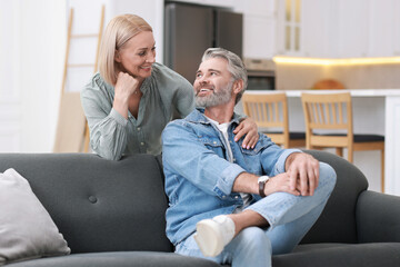 Wall Mural - Happy middle aged couple looking at each other in kitchen