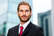 © Minerva Studio - Confident businessman smiling with office building in background
