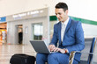 © Minerva Studio - Businessman working on laptop at airport