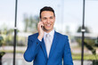 © Minerva Studio - Smiling businessman on phone outdoors