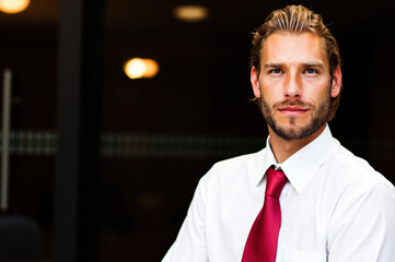 Portrait of confident businessman wearing white shirt and red tie