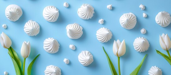 Poster - White tulips and meringue cookies against a blue background Copy space Top view