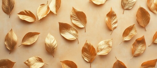 Leinwandbilder - Fall and autumn flat lay featuring creatively painted metallic golden leaves on a beige background copy space