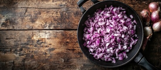 Fototapete - Chopped purple onion in a frying pan Copyspace Dark wooden backdrop Top view