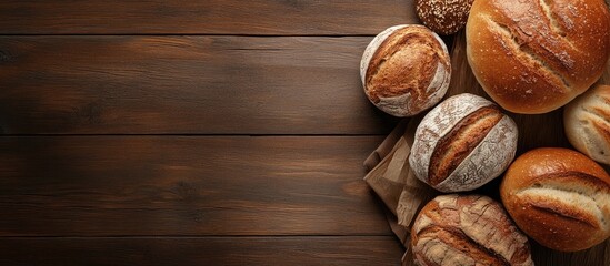 Poster - Selection of freshly baked bread and buns on a wooden table background top view. with copy space image. Place for adding text or design