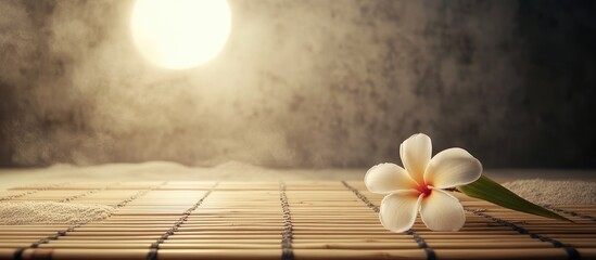 Poster - Health spa environment featuring a bamboo mat and frangipani flower on sand with a zen moon The photo is enhanced with a vintage retro filter. with copy space image. Place for adding text or design