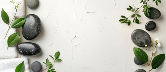 Poster - Spa set featuring stones a towel and leaves on a white background. with copy space image. Place for adding text or design