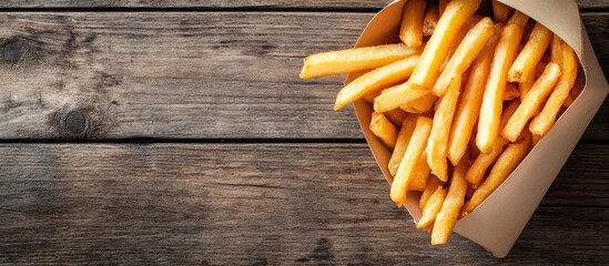 Poster - French fries on an old wooden table Top view. with copy space image. Place for adding text or design