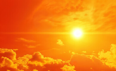 bright sun shining through fluffy clouds in orange sky