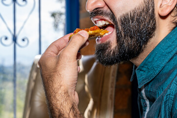 Man with beard at home eating typical Colombian dish, fish with coconut rice, banana and salad with orange juice. Colombian gastronomy.