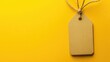 © Theeranan - Simple price tag tied with string, isolated against a vibrant yellow backdrop.