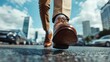 © JoxyAimages - Close-up of a person's shoe stepping forward on a wet city street, with modern skyscrapers and cars blurred in the background capturing urban movement.