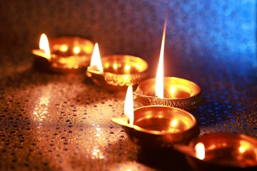 Diwali celebration. Diya lamps on color background, closeup