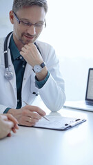 Doctor and a patient. The physician, wearing a white medical coat over a green shirt, gesturing with his hands during a consultation in the clinic. Medicine concept