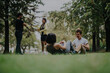 © qunica.com - A group of students engage in fitness exercises and discussions with their professor in a tranquil park setting. The image captures teamwork, learning, and the benefits of outdoor activities.