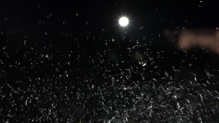 Poster - Mesmerizing water droplets in motion, illuminated by bright light against dark background, create magical night scene of reflection and shine, evoking tranquility and wonder.