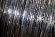 © Seventyfour - Dutch angle shot of shiny silver tinsel curtain reflecting light while decorating room for Christmas celebration, copy space