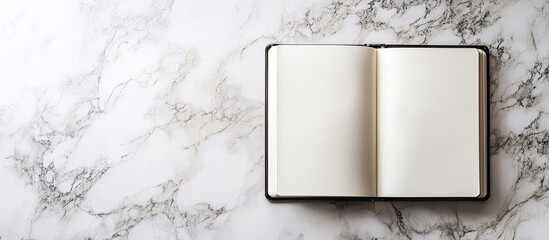 Poster - Blank sketchbook on a marble background Flat lay top view of an office table. with copy space image. Place for adding text or design