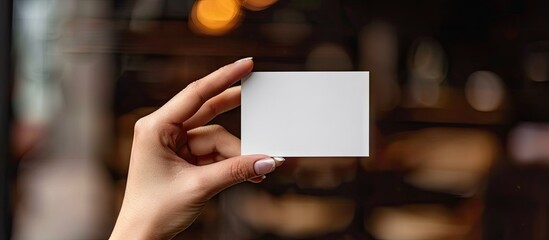 Leinwandbilder - A girl s hand is holding a blank business card The card is horizontal. with copy space image. Place for adding text or design