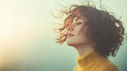 Wall Mural - A woman with curly hair is wearing a yellow sweater and looking up at the sky