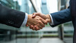 © Charly - business people shaking hands in front of buildings