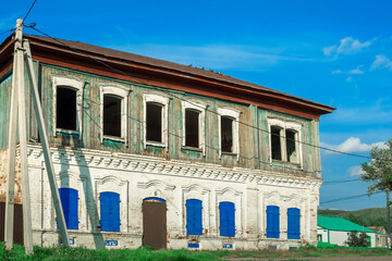 Carved window frames around an old house. View of a fragment of a house wall with carved decorations around the window and doors. Traditional Russian old houses. Close-up. Front view