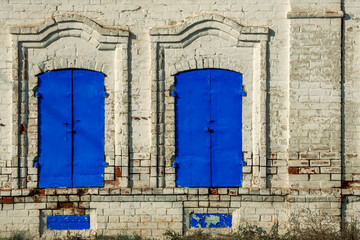 Carved window frames around an old house. View of a fragment of a house wall with carved decorations around the window and doors. Traditional Russian old houses. Close-up. Front view