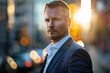 © Odin AI - A composed businessman in a suit gazes confidently at the camera with a city street background illuminated by a warm, setting sun, exuding determination and charm.