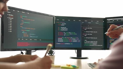 Slow motion back end software developer engineer for computer programming working together on debugging writing computing code, solving complex algorithms display on monitor in office. Burgeoning