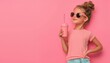 © WinThing - Girl in pink shirt and sunglasses, holding pink drink against pink background.