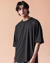 Stylish young man wearing a black t-shirt against a pastel background, embodying modern fashion trends.