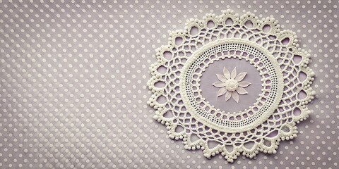 Poster - Intricate white crochet doily with beaded edging, resting on a background of delicate polka dot fabric.