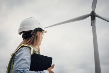 Poster - A skilled female engineer is managing wind turbine operations, playing a vital role in construction and engineering to promote environmental sustainability and contribute to a greener planet